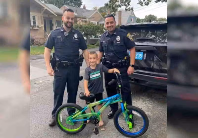 Os policiais com o garotinho Bryan, de 6 anos,, com a bike nova Foto: Polícia de Taunton