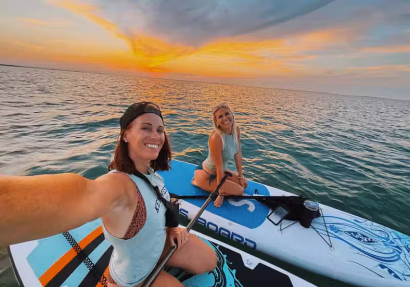 A mulher de cabelos escuros é Charity, corajosa, que salva um tubarão enquanto fazia stand-up paddle com amigos. Foto: MSN