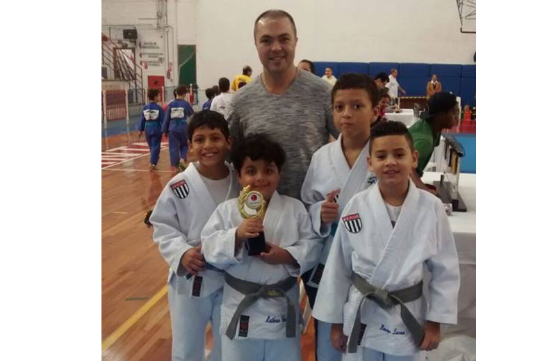 Matheus com o ídolo Rogério e a equipe de judocas do FPJ