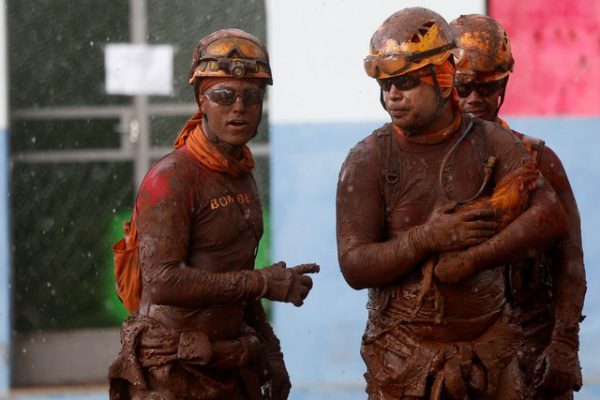 Bombeiros sujos de lama resgatam galo - Foto: Adriano Machado/Reuters