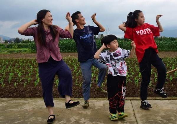 O casal se apresenta com seus filhos no campo. Foto: Xinhua