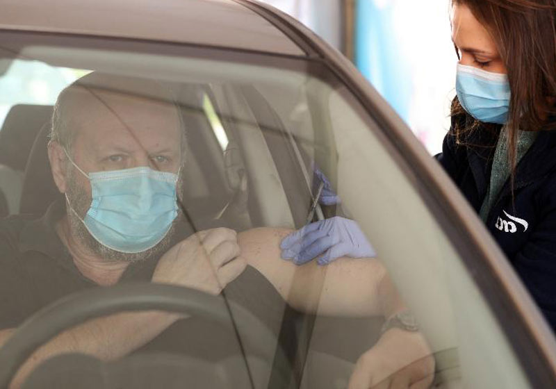 Homem é vacinado em drive-through de Haifa, Israel - Foto: Ammar Awad/Reuters