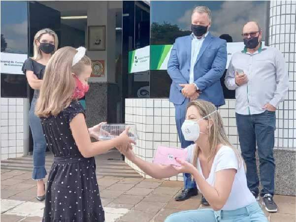 Larissa, gerente do HCC, entrega um bolo de chocolate para Pietra, como agradecimento pela doação. - Foto: HCC