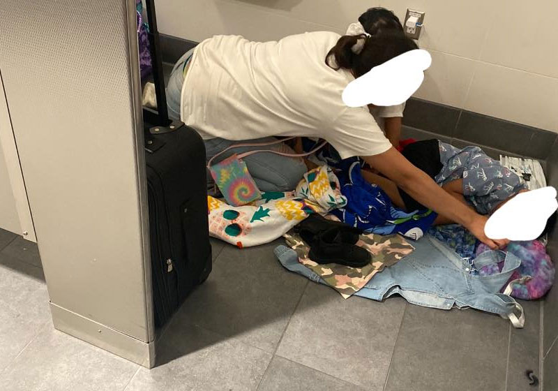 Mulher dormia no chão do aeroporto com o filho pequeno. - Foto: reprodução Cyn Simoné