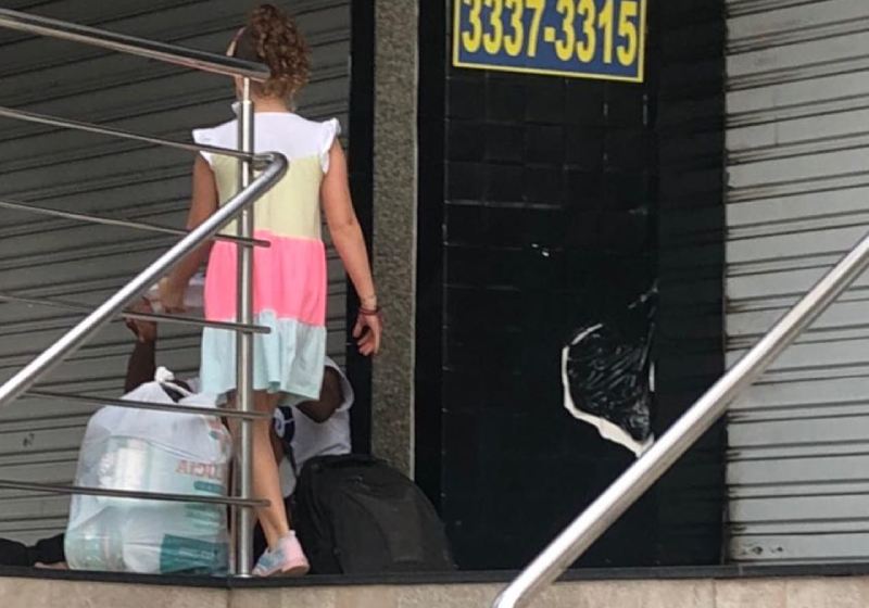 Luiza entregando a comida ao morador em situação de rua - Foto: reprodução / Facebook