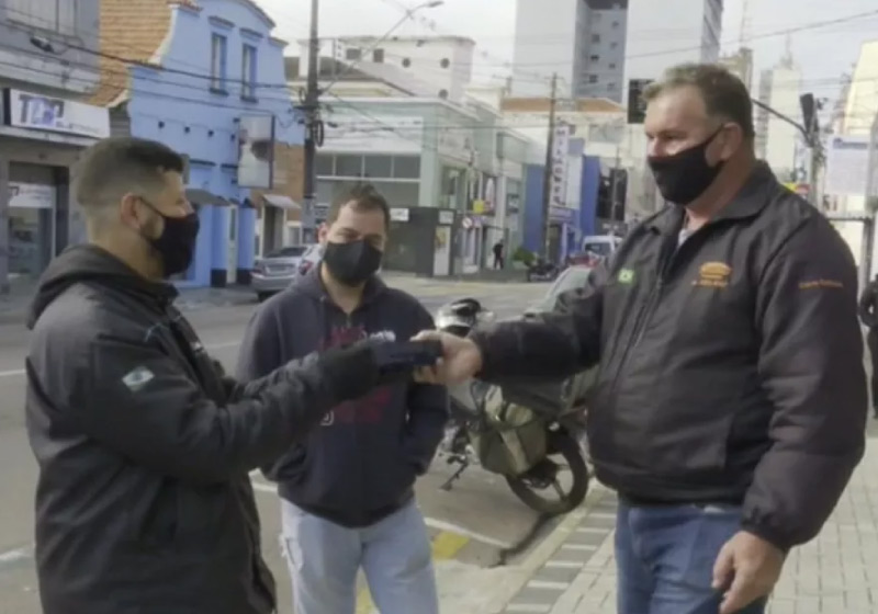 O chaveiro Ademir com Giovanne e o entregador na entrega da encomenda perdida: um celular - Foto: Reprodução/RPC