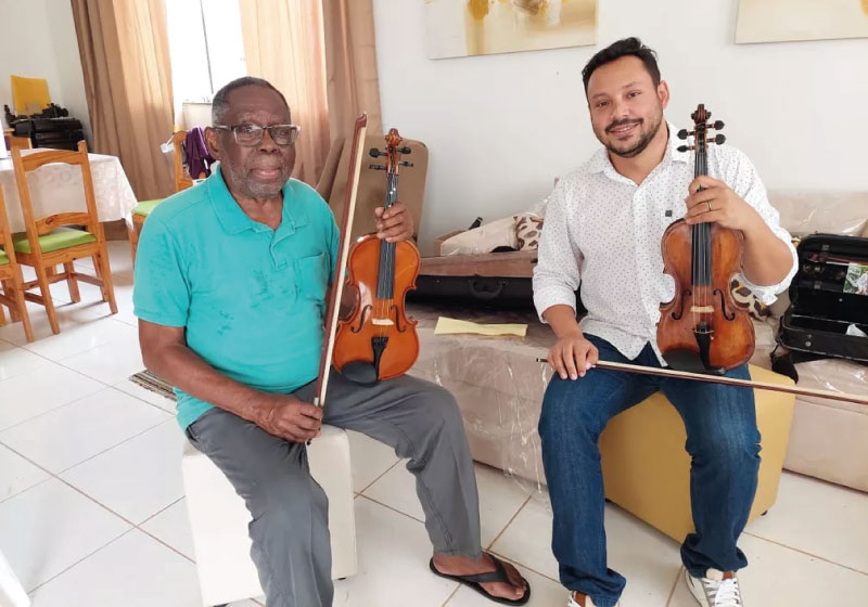 Nerlson e o professor de violino, Giovanny Conte. O aposentado sempre sonhou em tocar um instrumento. — Foto: Karla Mendes