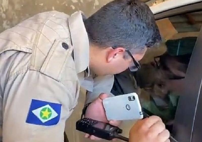 O bombeiro passando desenho da Galinha Pintadinha no celular para acalmar o garotinho - Foto: divulgação