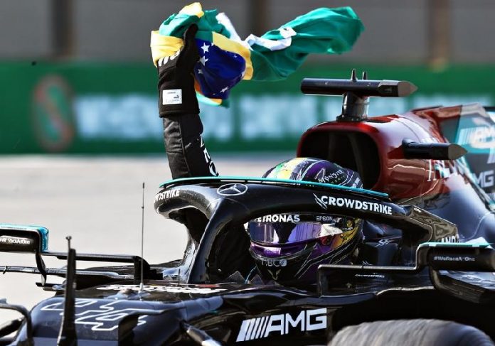 Lewis Hamilton emocionou a torcida ao levantar a bandeira do Brasil, em homenagem a Senna, na vitória do GP Brasil de F1 - Foto: Buda Mendes/Getty Images