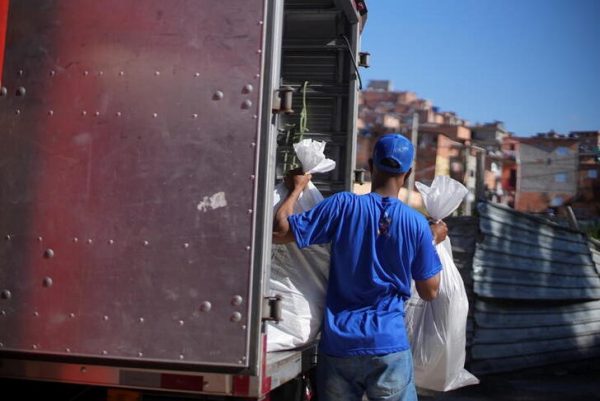 Integrante do do Favela Brasil Xpress entregando em Paraisópolis - REUTERS/Leonaro Benassatto