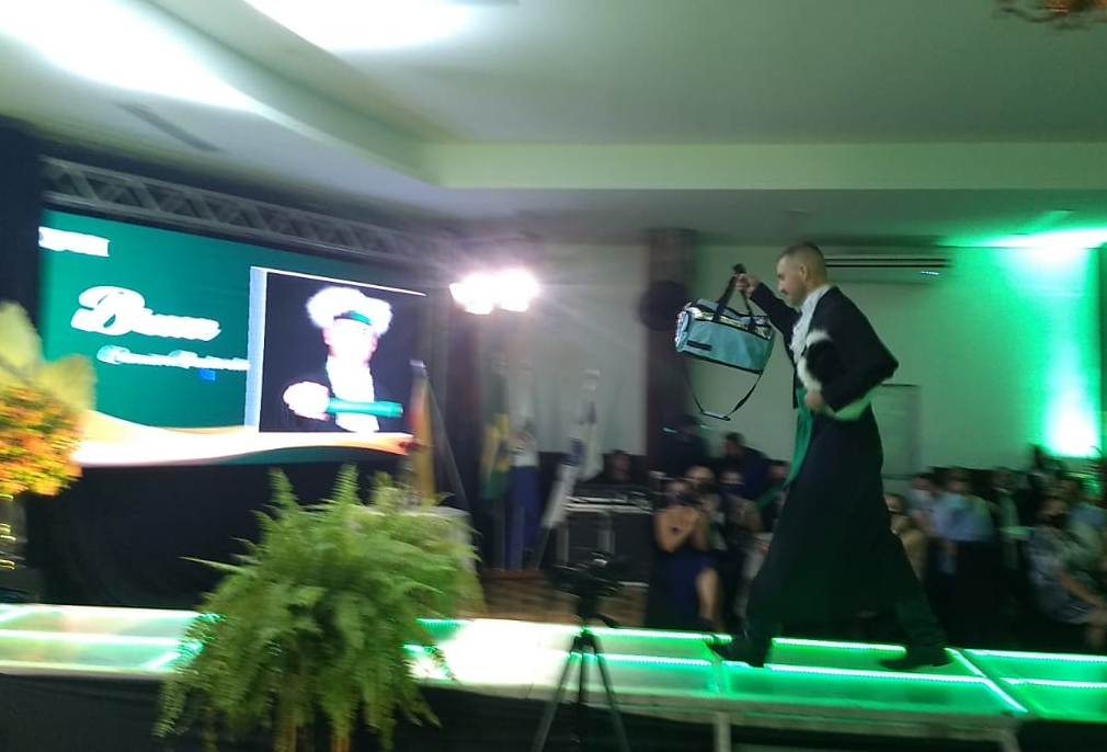 Bruce entrando na colação de grau com a bolsa térmica em homenagem à mãe - Foto: reprodução / URI