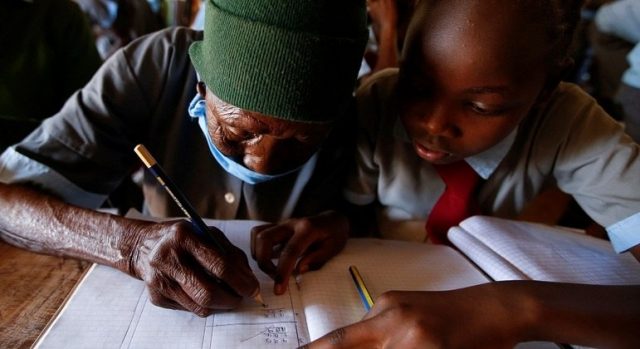 A vovó de 98 anos estudando com uma das notinhas - Foto: REUTERS/ Monicah Mwangi