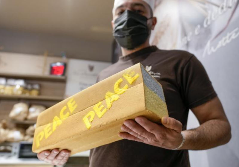 O padeiro Matteo Cunsolo segura o 'pão da paz' ​​que ele assa em Parabiago para beneficiar os refugiados Rússia-Ucrânia. Foto AP/Luca Bruno
