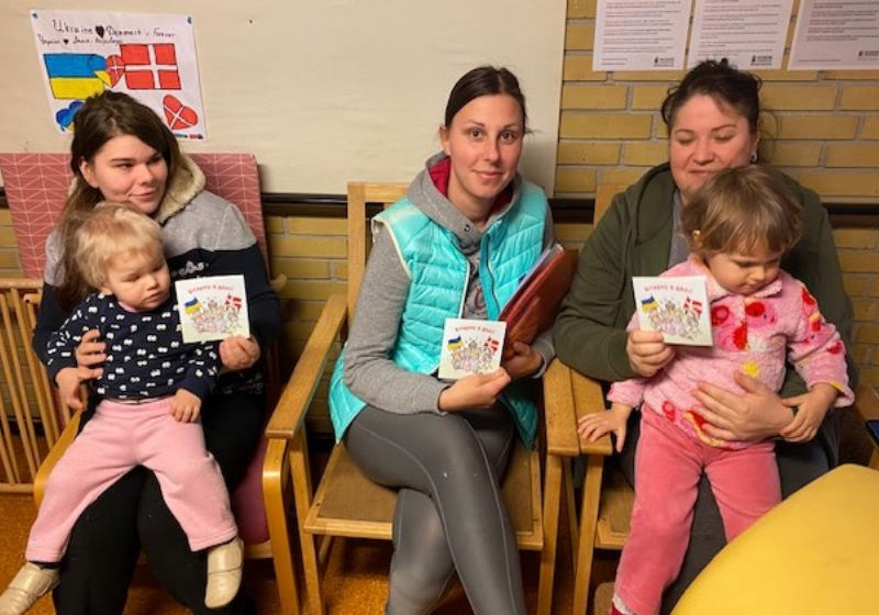 Refugiados recebem o livro feito especialmente para que eles possam se sentir em casa Foto: Mediabrands Content Studio