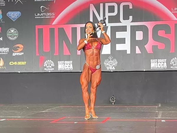 Priscila levanta o trofeu de campeã de fisiculturismo no NPC Universe - Foto: reprodução 