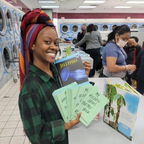 Kaila mostra alguns exemplares da livraria - Foto: reprodução Facebook