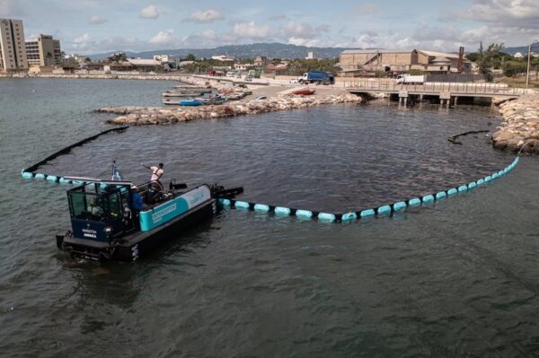 Equipamento da ONG The Ocean Cleanup em operação na foz de um rio na Jamaica. Imagem: Divulgação/The Ocean Cleanup
