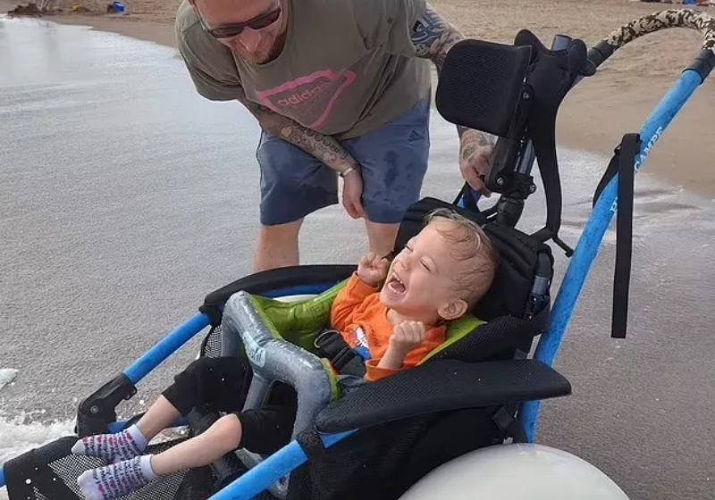 O menino curtiu a praia pela primeira vez graças a uma cadeira especial - Foto: reprodução