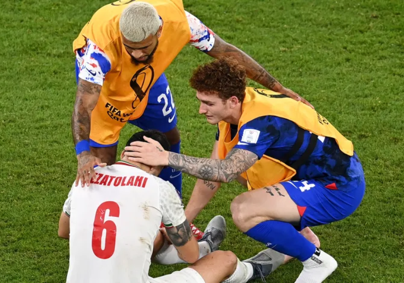 Jogadores dos Estados Unidos consolam iranianos chorando no campo após a partida - Foto: reprodução