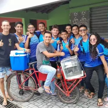 Os alunos ao lado do vendedor de lanches, que trabalha de bicicleta para se manter - Foto: reprodução / redes sociais