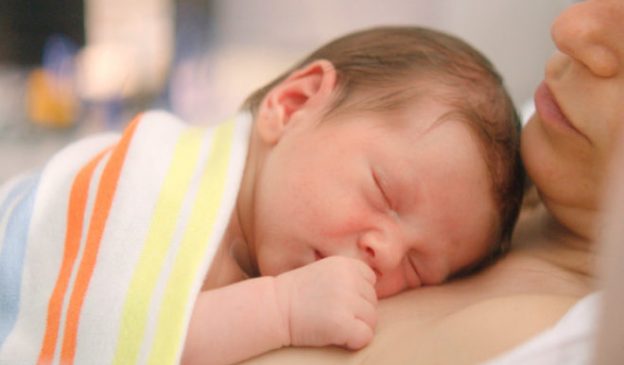 Enrolar a criança em um pequeno pano e traze-lá junto ao corpo acalma o bebê, reduz a ansiedade da mãe e muito mais! Foto: Reprodução/Instituto Villamil.
