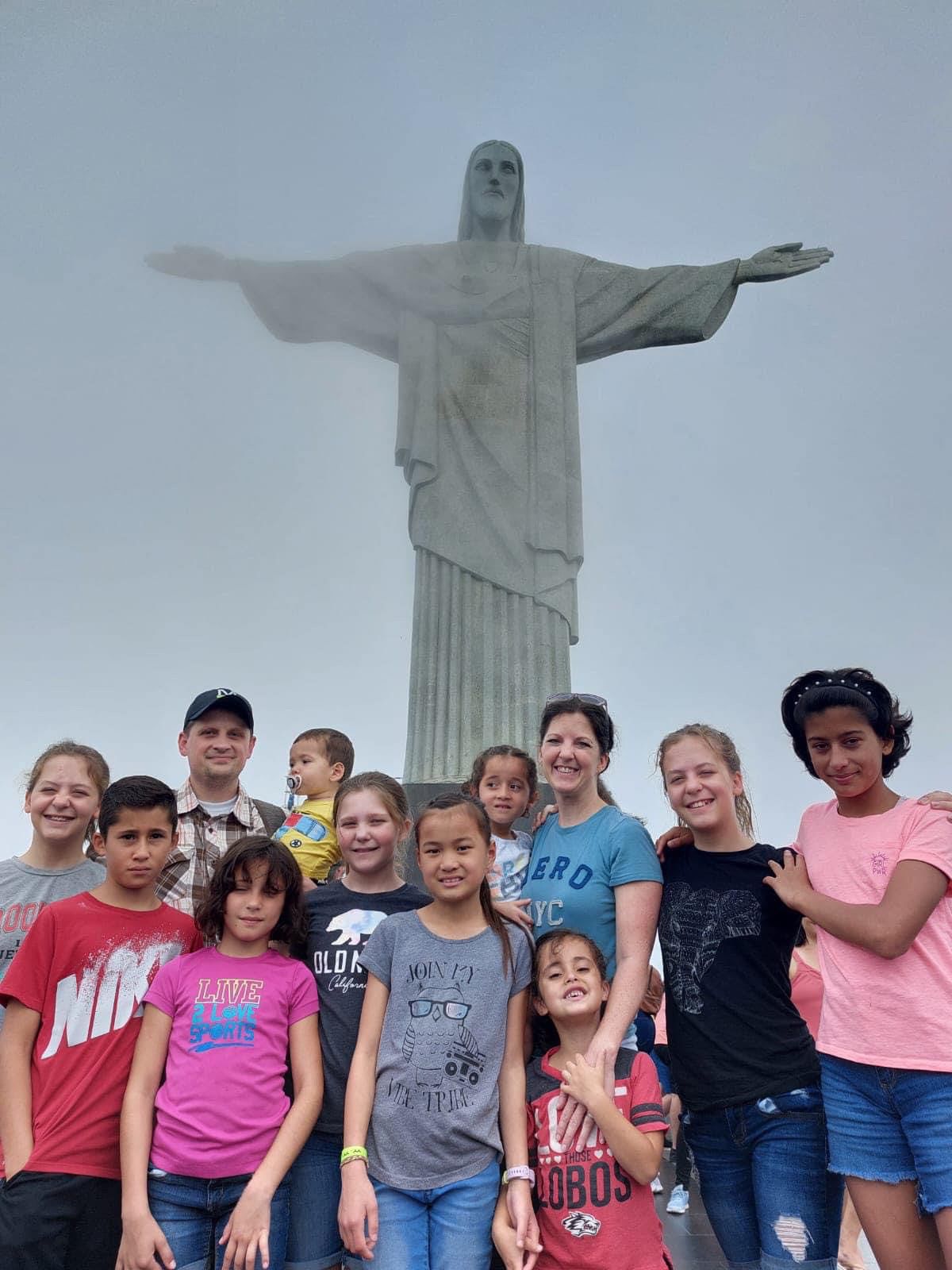 Aos pés do Cristo Redentor, Jill, Adam e os 6 irmãos brasileiros que eles adotaram. A família já embarcou para os Estados Unidos. Foto: arquivo pessoal