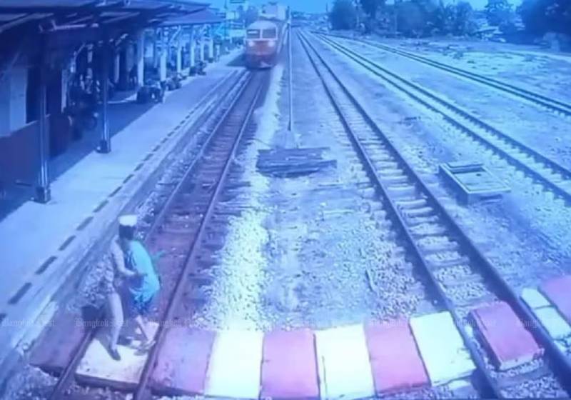 O funcionário empurrou a idosa deficiente auditiva segundos antes de o trem passar! - Foto: Reprodução/ State Railway of Thailand