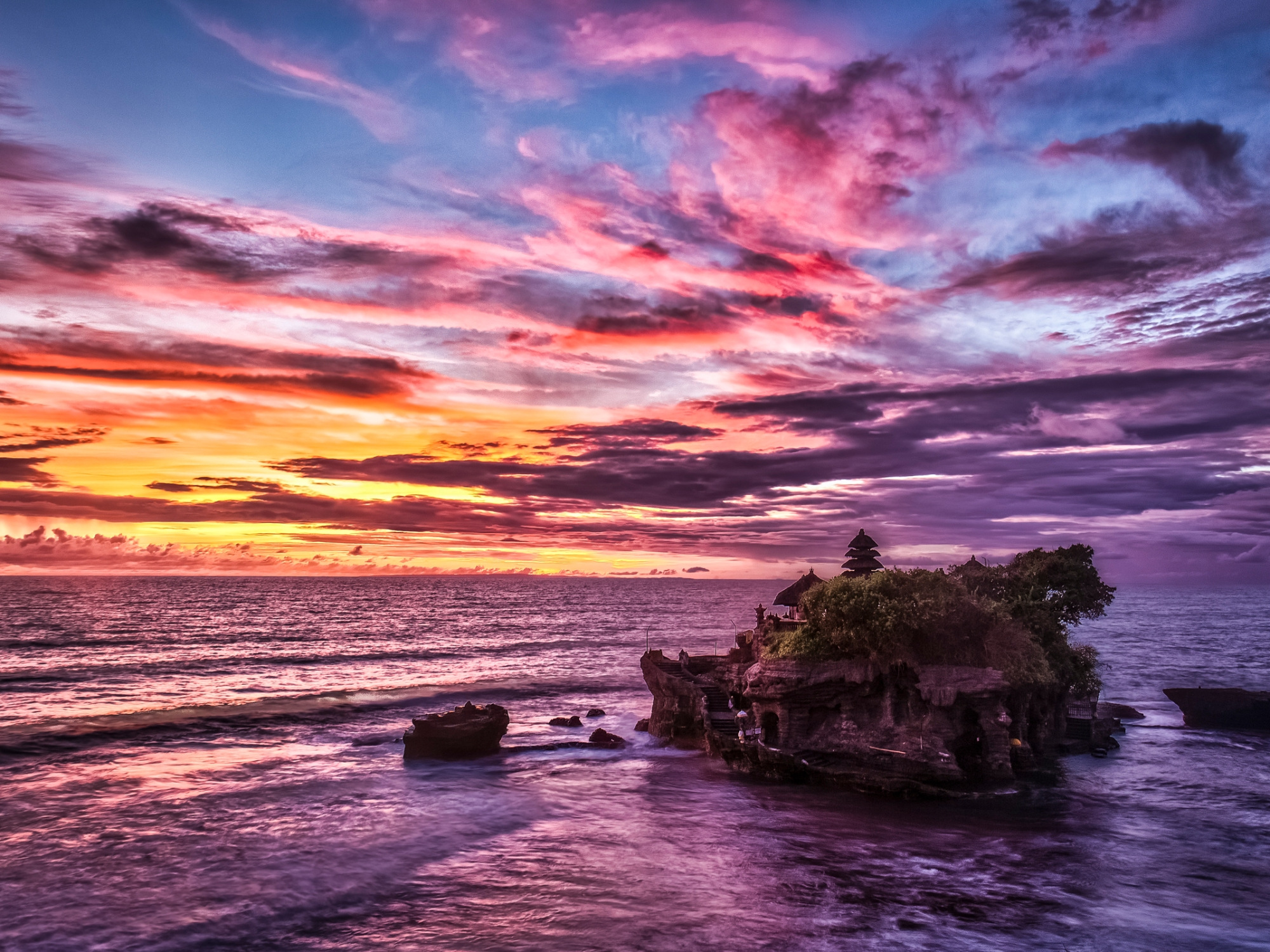 O por do sol no tempo de Tanah Lot, em Bali, é uma das coisas mais bonitas do mundo. Olha essa cor, gente! Foto: Reprodução/Backpackerlee.