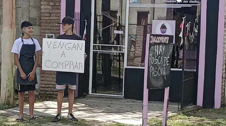 O garoto Leonel, de 14 anos, foi para a frente da loja com o cartaz chamando clientes e fez o comércio da mãe lotar. - Foto: reprodução / Luján 365e da loja com a placa chamando clientes e fez o comércio da mãe lotar - Foto: reprodução / Luján 365