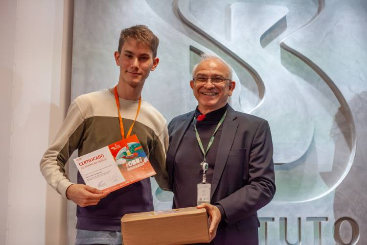 João Tomás, um dos medalhistas na OBB e na IBO, recebeu certificado das mãos do diretor de Imunobiológicos do Butantan, Rui Curi. Foto: Reprodução/Instituto Butantan.