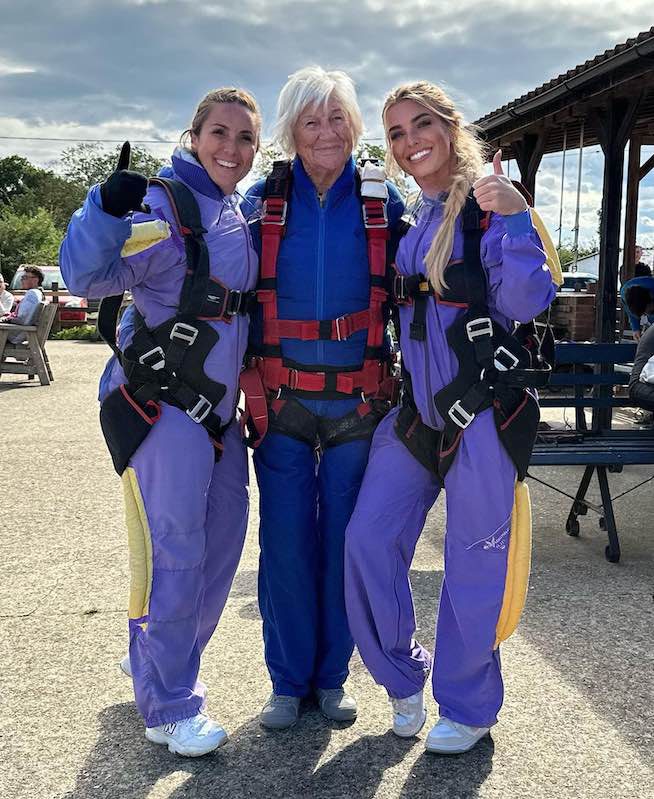 A vovó Hilary Oxley, de 90 anos, que saltou de paraquedas, com suas netas Stephanie (esq.) e Daisy (dir.) – Foto: SWNS