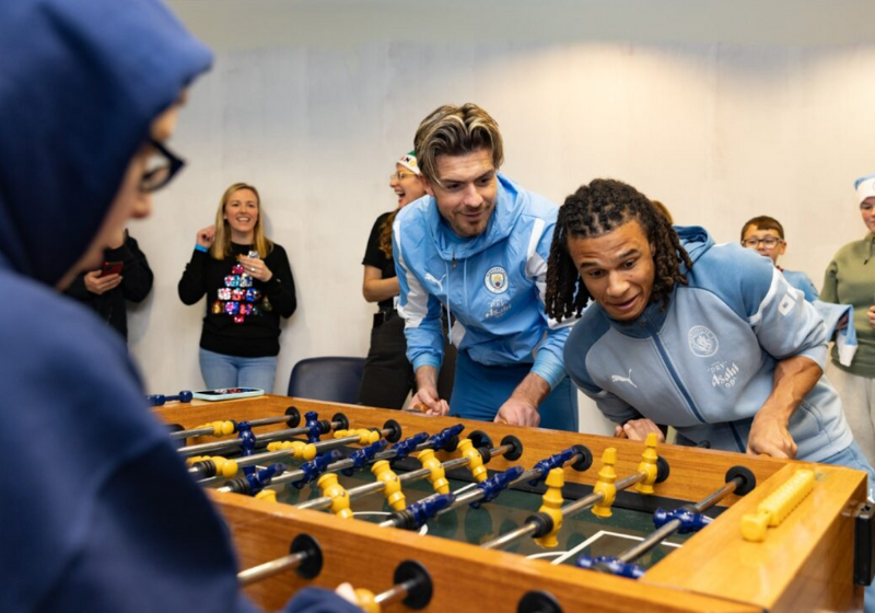 Durante a visita, eles foram desafiados para uma partida de totó. Foto: Reprodução/Manchester City.