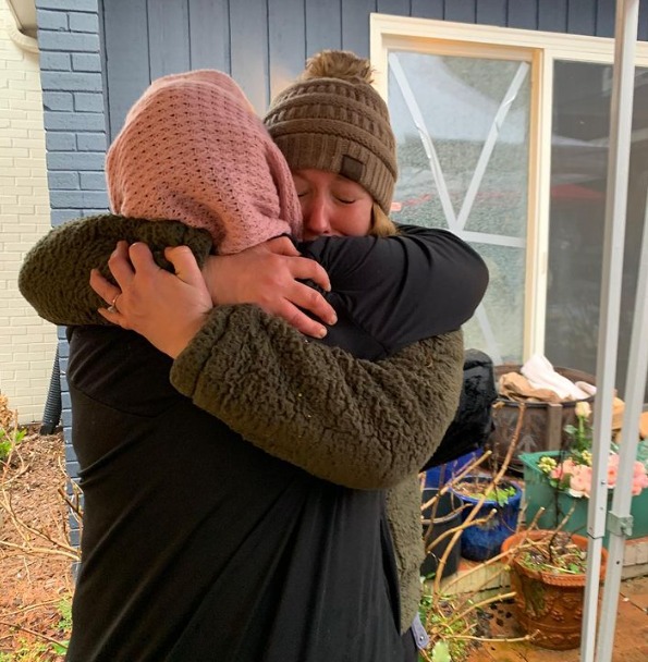 Ashley abraça uma mulher que recebeu flores do projeto. - Foto: reprodução/Instagram @prettythings.charlotte