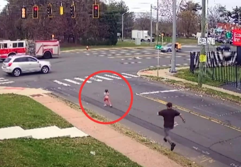 A ação rápida desses dois heróis evitou que a garotinha se machucasse ao correr freneticamente pela rua em direção a um cruzamento perigoso. - Foto: Imagens de segurança