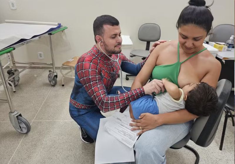 O médico pediatra Thiago Moisés atende um dos pequenos pacientes vestido de Homem-Aranha — Foto: Divulgação/IgesDF