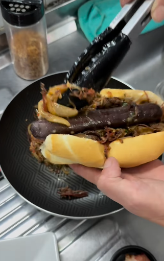 A base do cachorro-quente é uma carne desfiado e cebola caramelizada. - Foto: @ocaiomuniz/Instagram