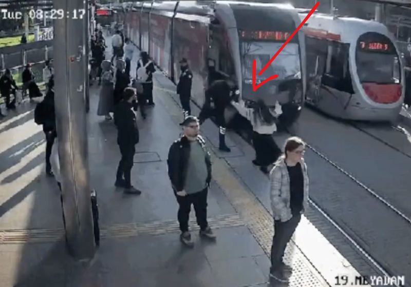 Um guarda muito atento salva a mulher distraída que seria atropelada pelo trem na estação da Turquia. Ele puxa o braço dela na hora H. - Foto: câmeras de segurança