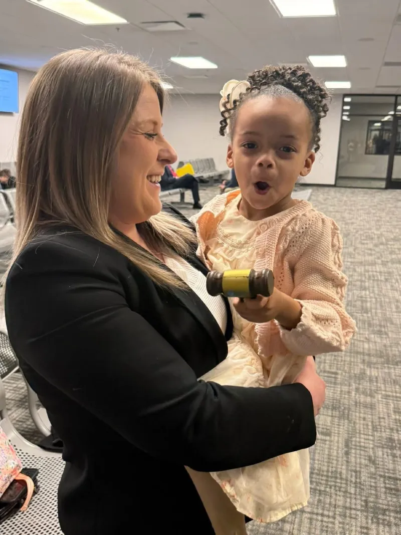 A delegada com a filha no colo após a adoção oficializada. - Foto: Polícia de Greenville
