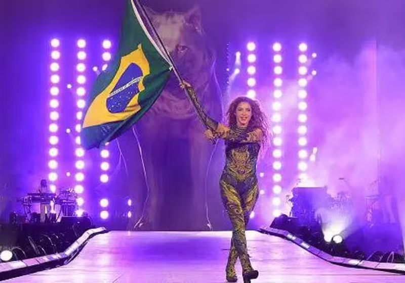Shakira abriu o show no Rio com a bandeira do Brasil no peito e terminou com carregando outra bandeira gigante do país. - Foto: Getty Images