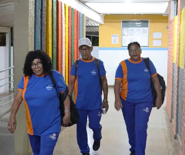 Selma caminha pelo corredor da escola com os pais, Francisco e Maria da Paz, que também voltaram a estudar - Foto: Prefeitura de Goiânia/Reprodução