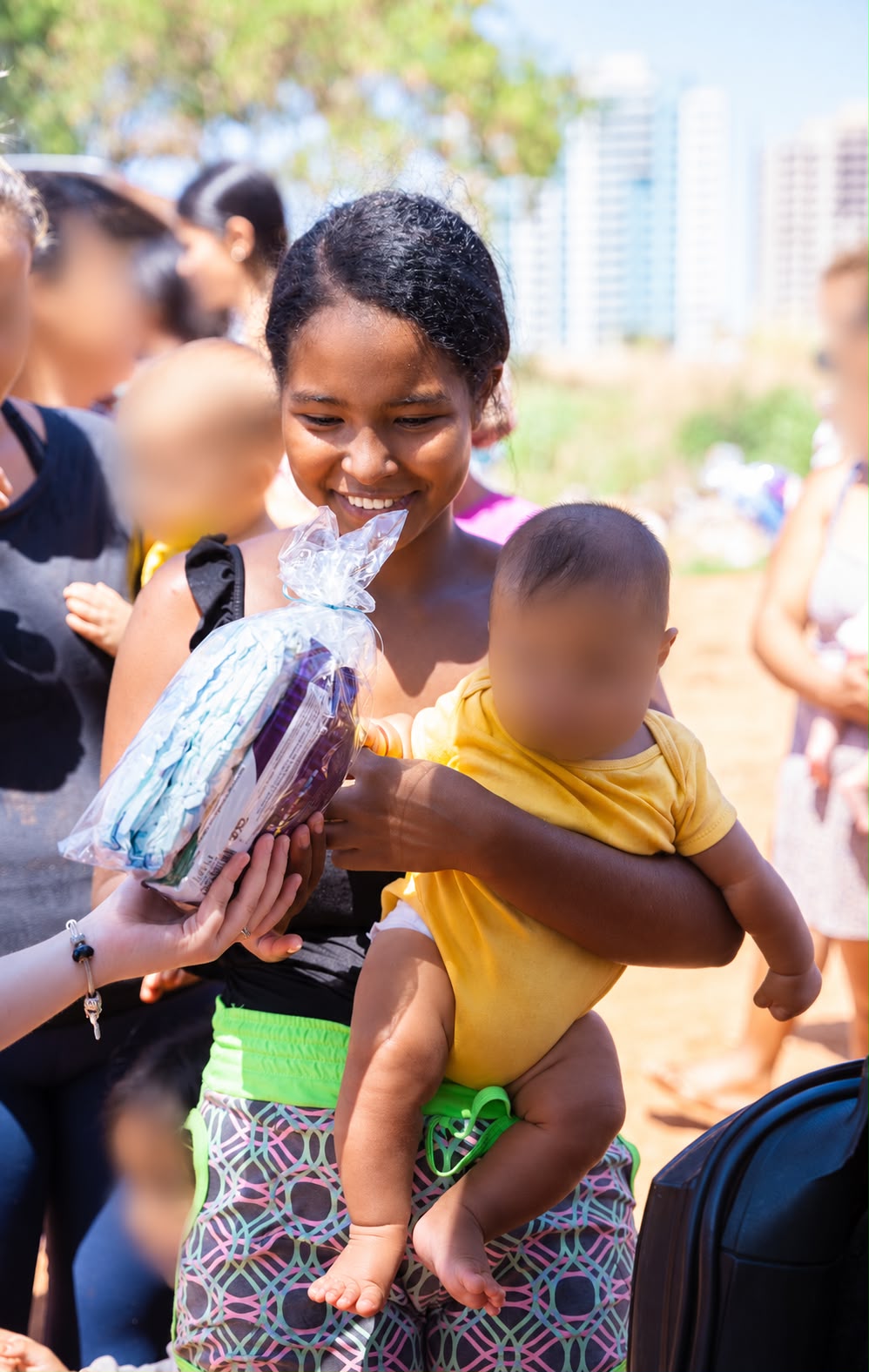 Equipe entrega uma bicicleta a uma criança durante a distribuição de doações. Foto: Arquivo pessoal/Reprodução/Instagram/@diadascriancasnaquebrada