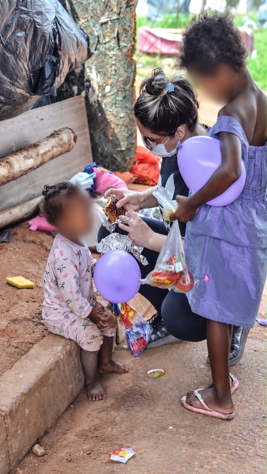 Voluntária entrega hambúrguer a uma das crianças atendidas pelo projeto. Foto: Arquivo pessoal/Reprodução/Instagram/@diadascriancasnaquebrada