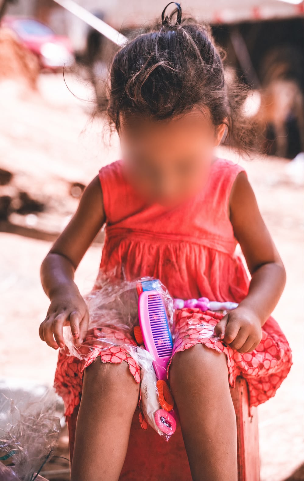 Criança observa curiosa os itens de um kit de cabelo recebido durante a ação. Foto: Arquivo pessoal/Reprodução/Instagram/@diadascriancasnaquebrada