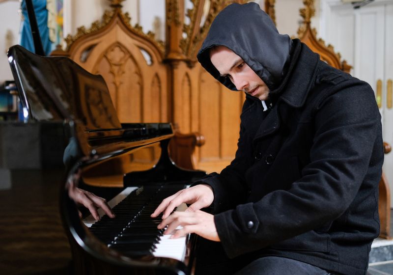Rhys Wynne-Jones, o pianista ex-sem-teto, ficou conhecido após um vídeo dele tocando “Bohemian Rhapsody”., do Queen, em uma igreja viralizar em 2024. - Foto: Rhys Wynne-Jones