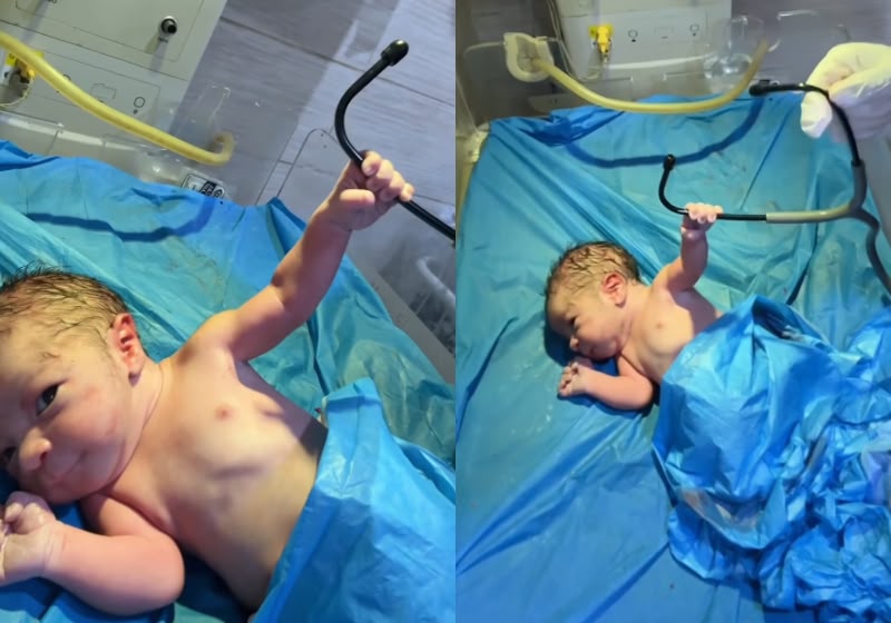 Recém-nascido chama a atenção pelo bracinho fortinho e pelo sorriso enquanto agarra o estetoscópio do médico. Foto: Reprodução/Instagram @drnewborns.