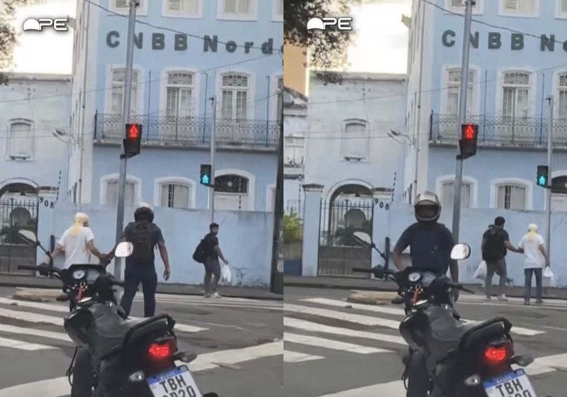 Motociclista ajuda idosa a atravessar e outro homem se aproxima para terminar o caminho até a calçada, no Recife. - Foto: Reprodução/ Instagram/ Bom Dia Pernambuco